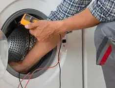 Washing machine repair technician testing a front-load washer with diagnostic tools in Charlotte, NC